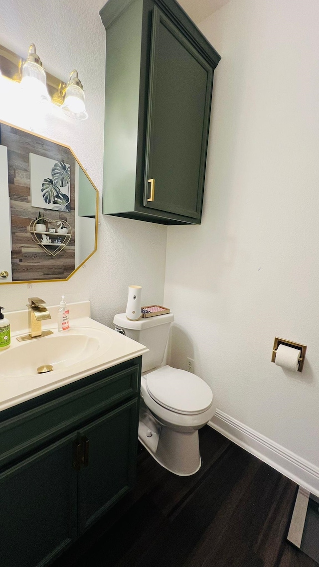 bathroom featuring vanity, hardwood / wood-style flooring, and toilet