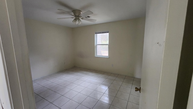 spare room with ceiling fan and light tile patterned floors