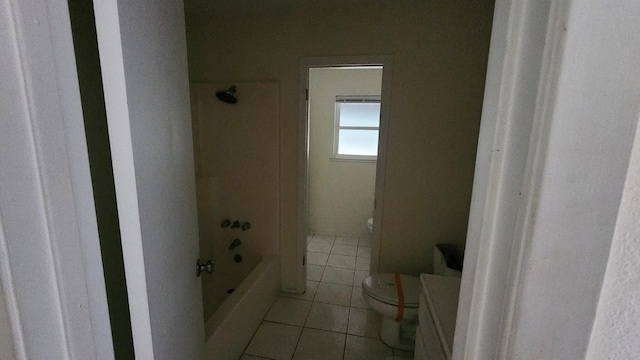 bathroom with tile patterned flooring, bathing tub / shower combination, and toilet