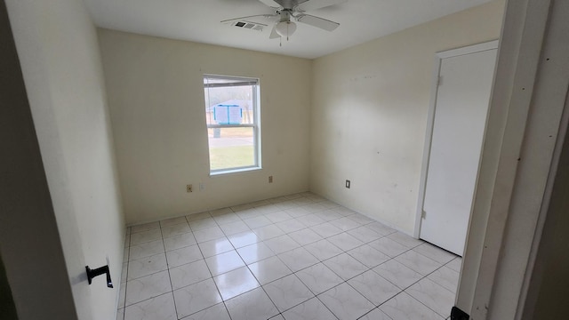 tiled spare room featuring ceiling fan