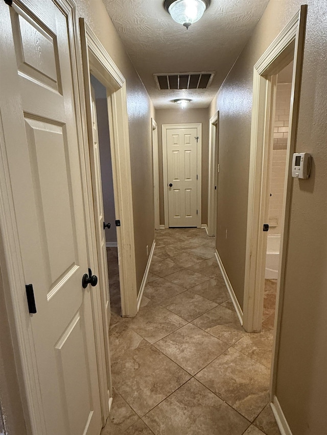 corridor featuring a textured ceiling