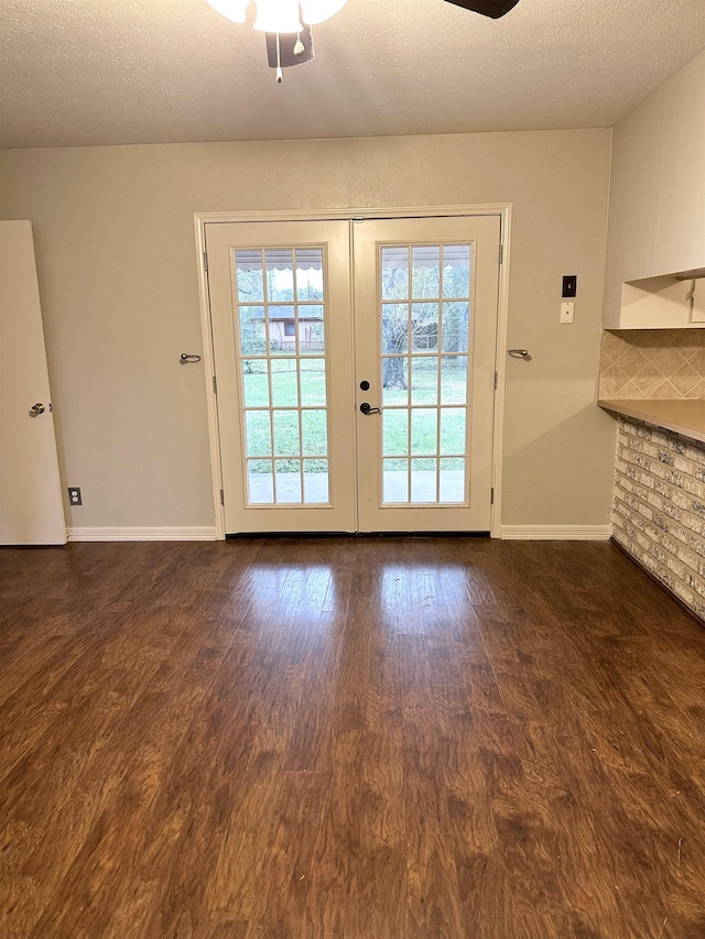 doorway to outside featuring dark hardwood / wood-style floors, ceiling fan, a textured ceiling, and french doors