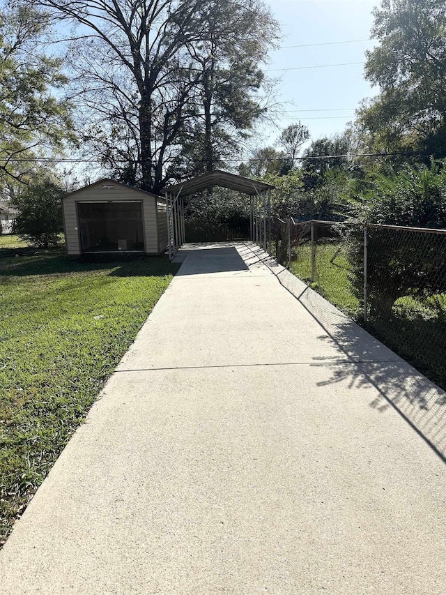 exterior space with an outbuilding, a garage, a carport, and a lawn