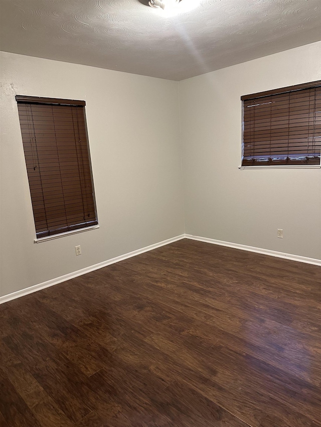 spare room featuring hardwood / wood-style floors and a textured ceiling