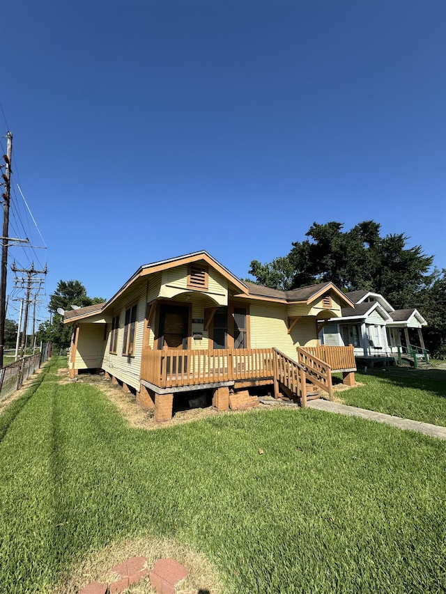 view of front facade featuring a front lawn and a wooden deck