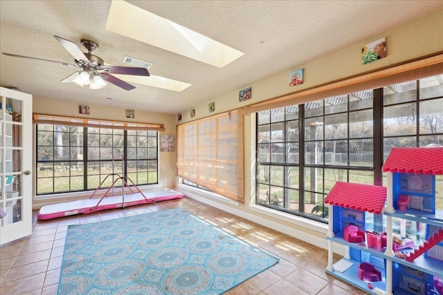 playroom with tile patterned floors, plenty of natural light, and a skylight