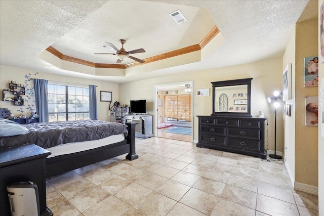 bedroom with crown molding, ceiling fan, a tray ceiling, and a textured ceiling