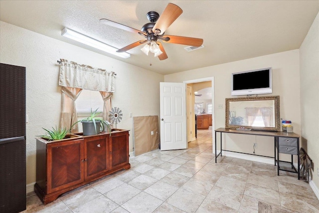 interior space with ceiling fan