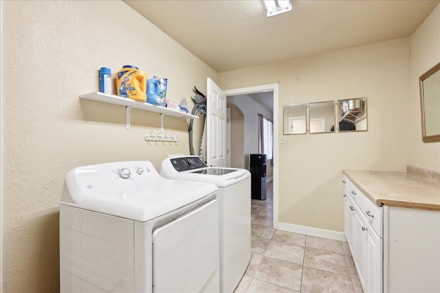 laundry room featuring cabinets, independent washer and dryer, and light tile patterned floors