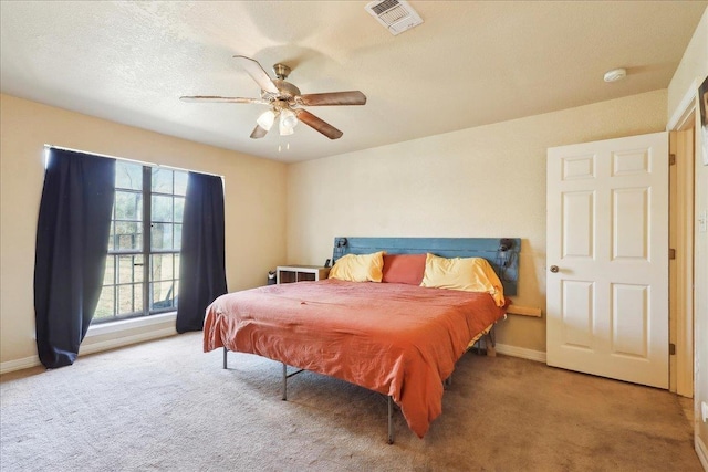 carpeted bedroom with a textured ceiling and ceiling fan