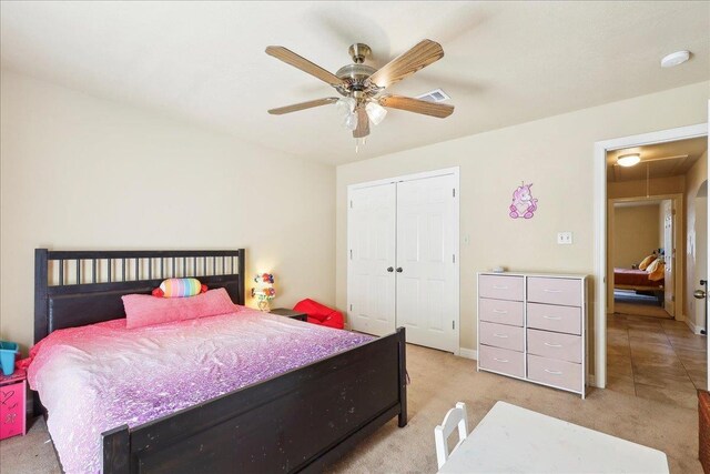 bedroom with ceiling fan, light colored carpet, and a closet