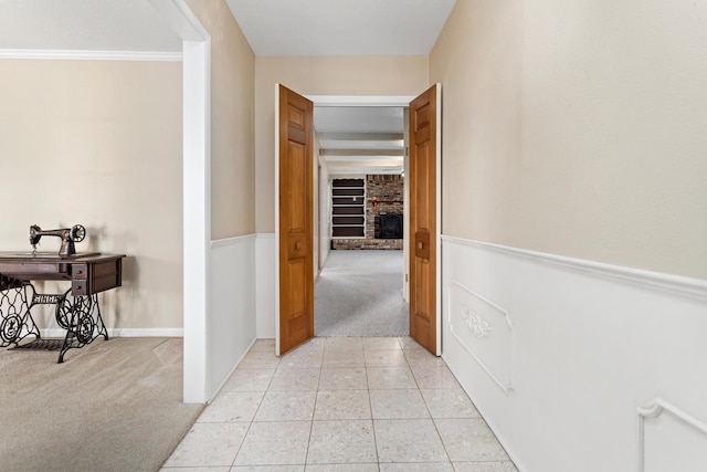 hall featuring light carpet and ornamental molding