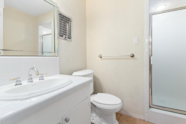 bathroom featuring tile patterned flooring, backsplash, an enclosed shower, toilet, and vanity