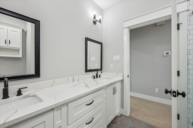 full bathroom featuring double vanity, baseboards, and a sink