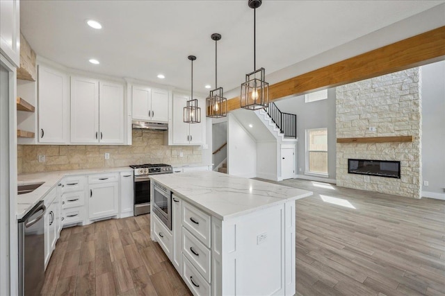 kitchen featuring tasteful backsplash, a fireplace, stainless steel appliances, white cabinetry, and open shelves