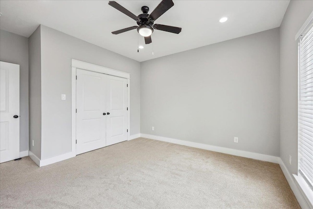 unfurnished bedroom featuring light carpet, recessed lighting, a closet, and baseboards