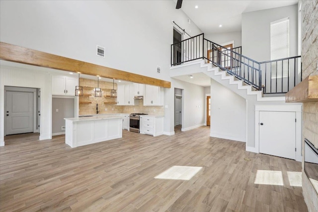 unfurnished living room featuring visible vents, baseboards, and light wood-type flooring