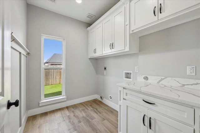 laundry area featuring light wood finished floors, visible vents, washer hookup, cabinet space, and electric dryer hookup
