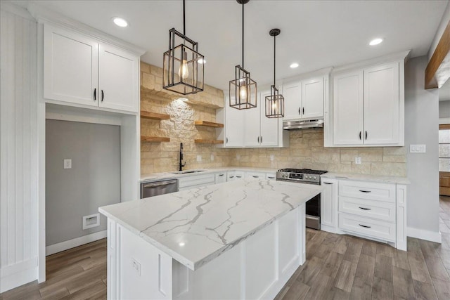 kitchen featuring under cabinet range hood, a sink, appliances with stainless steel finishes, white cabinets, and decorative backsplash