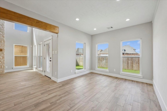 unfurnished room with visible vents, recessed lighting, light wood-type flooring, and baseboards