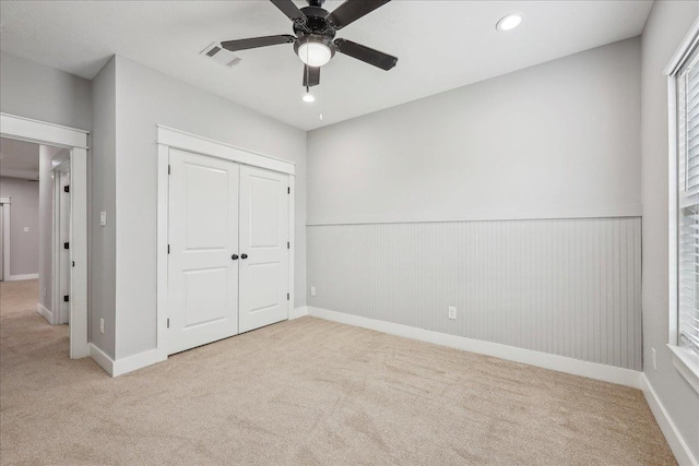 unfurnished bedroom with visible vents, carpet floors, wainscoting, recessed lighting, and a closet