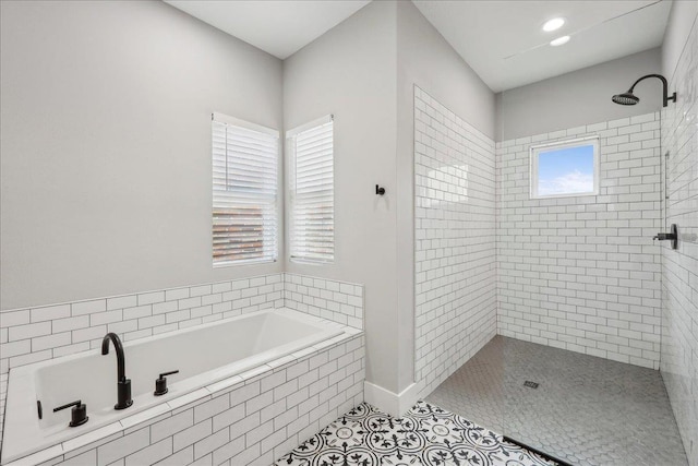 full bath featuring tile patterned flooring, a healthy amount of sunlight, a stall shower, and a garden tub