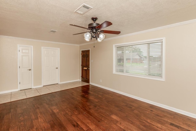 unfurnished room with a textured ceiling, light hardwood / wood-style flooring, ceiling fan, and crown molding