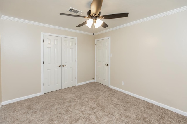 unfurnished bedroom with a closet, ceiling fan, crown molding, and light carpet