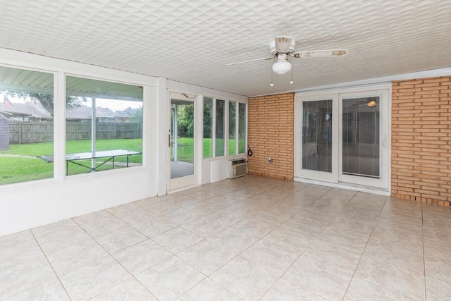 unfurnished sunroom featuring ceiling fan