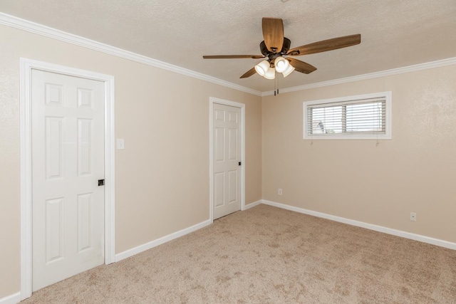 empty room featuring crown molding, ceiling fan, light carpet, and a textured ceiling