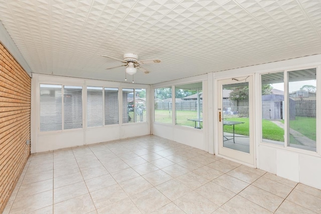 unfurnished sunroom featuring ceiling fan