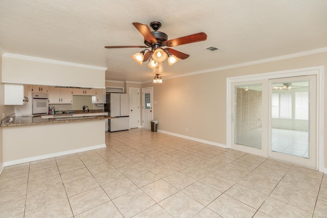 kitchen featuring light stone countertops, a textured ceiling, white appliances, crown molding, and light tile patterned floors