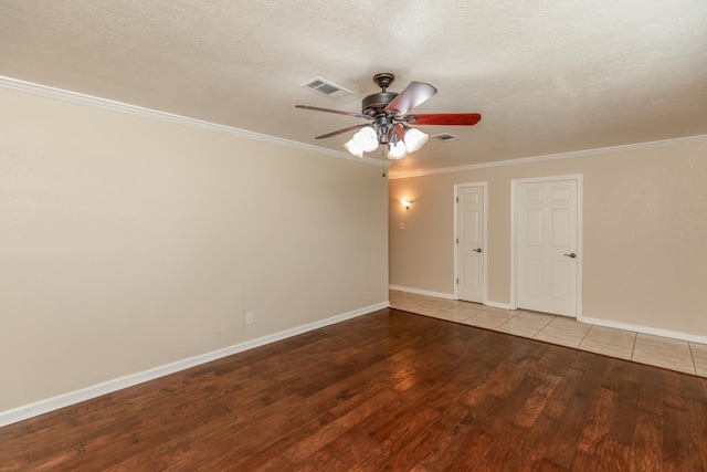 empty room featuring ceiling fan, light hardwood / wood-style flooring, a textured ceiling, and ornamental molding