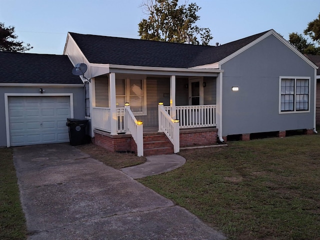 ranch-style house with covered porch, a garage, and a front lawn