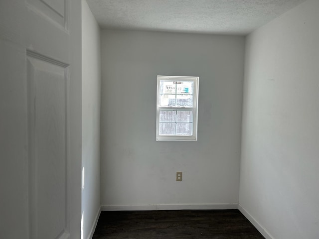 unfurnished room with dark hardwood / wood-style flooring and a textured ceiling