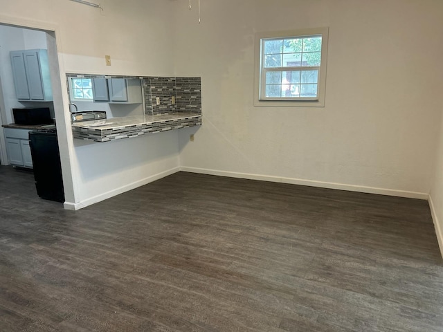 kitchen featuring tasteful backsplash, kitchen peninsula, and dark hardwood / wood-style flooring