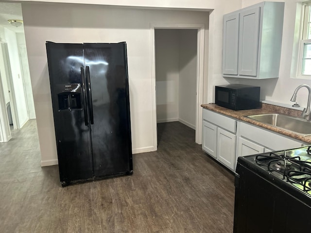 kitchen with dark wood-type flooring, white cabinetry, sink, and black appliances