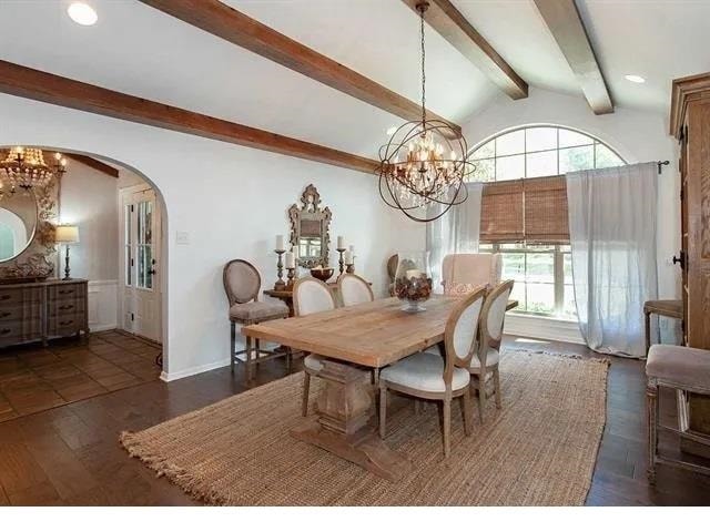 dining room with dark hardwood / wood-style flooring, lofted ceiling with beams, and a notable chandelier