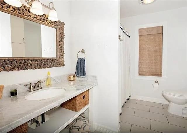 bathroom with tile patterned flooring, toilet, and sink