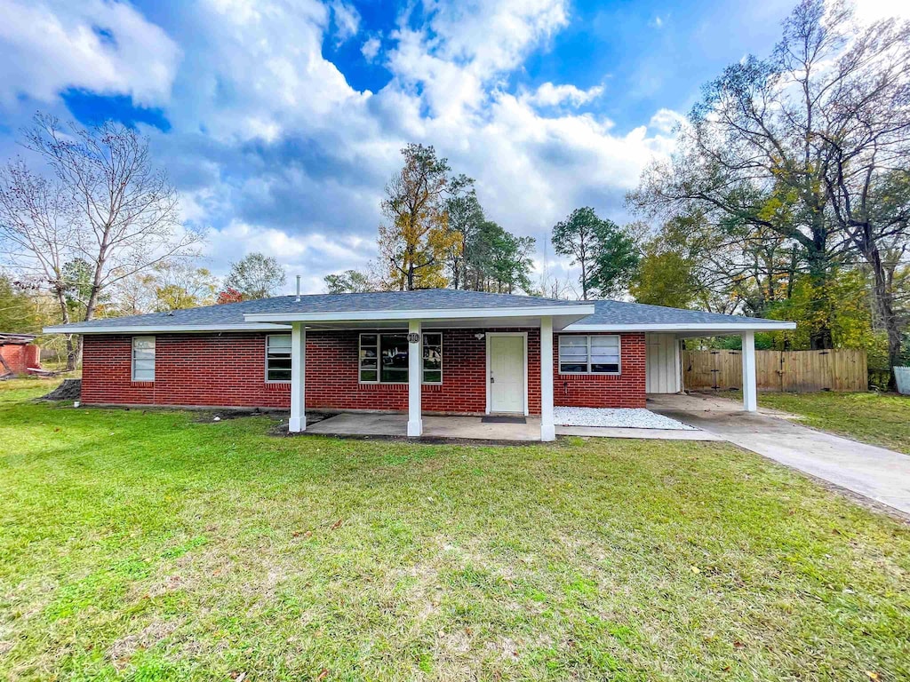 ranch-style house featuring a front yard and a carport