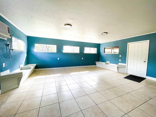 bathroom featuring tile patterned floors, a wall mounted AC, crown molding, and a textured ceiling