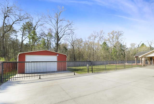 exterior space featuring a garage, an outdoor structure, fence, and a gate