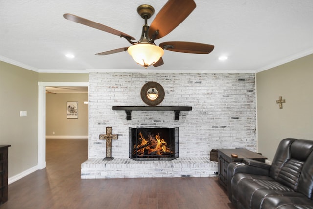 living area with crown molding, a ceiling fan, a brick fireplace, wood finished floors, and baseboards