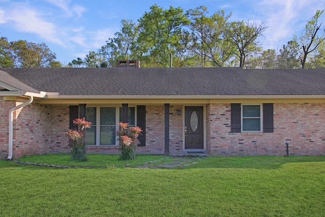 single story home featuring brick siding, a front lawn, and a shingled roof