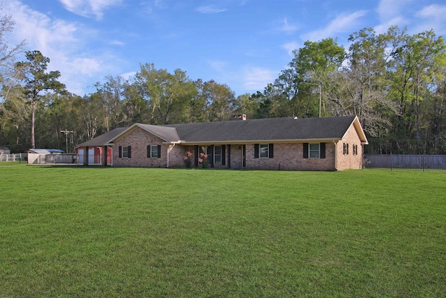 single story home featuring brick siding, a chimney, a front yard, and fence