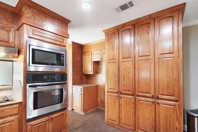 kitchen featuring visible vents, brown cabinetry, dark wood-type flooring, stainless steel appliances, and light countertops