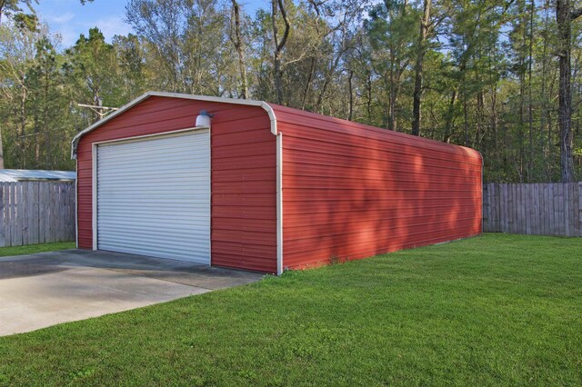 detached garage with fence and concrete driveway