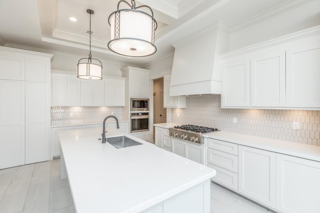 kitchen with pendant lighting, white cabinetry, sink, custom exhaust hood, and stainless steel appliances