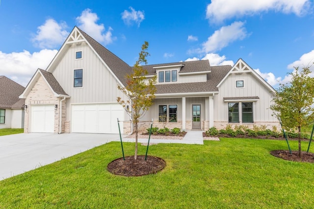 view of front of house with a garage, covered porch, and a front lawn