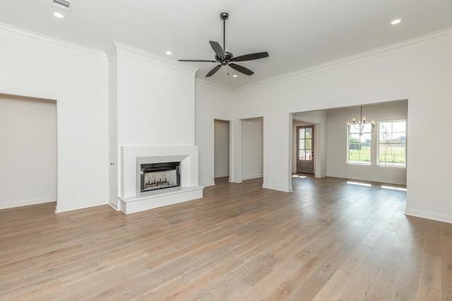 unfurnished living room featuring crown molding, ceiling fan with notable chandelier, and light hardwood / wood-style flooring